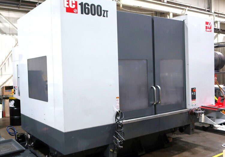 A large industrial CNC machine labeled "EC 1600ZT" in a factory setting.